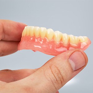Close-up of hand holding a denture