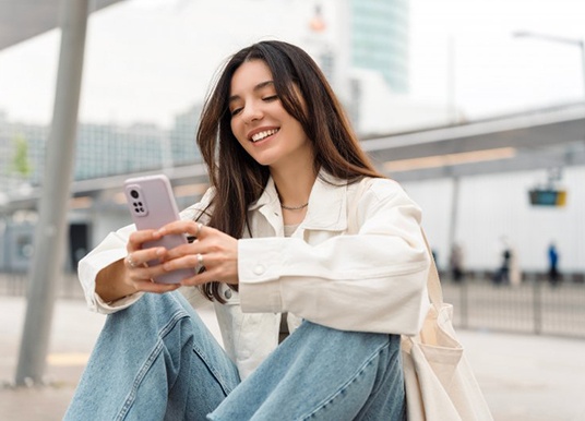 Smiling lady reads something on smartphone