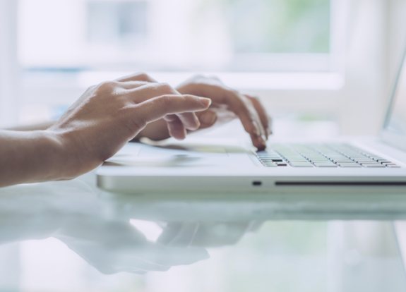 Person typing on laptop keyboard