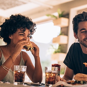 Group of friends smiling while eating lunch