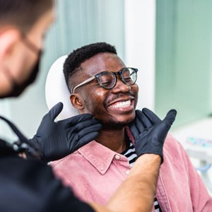 Dentist looking at patient's smile in treatment room
