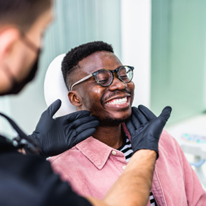 Dentist looking at patient's smile in treatment room