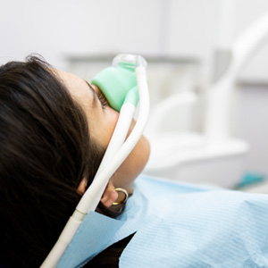 Patient with nasal mask relaxing in treatment chair