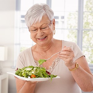 Senior woman with glasses eating a salad