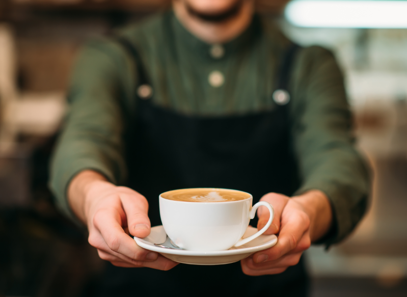 Barista holding out coffee